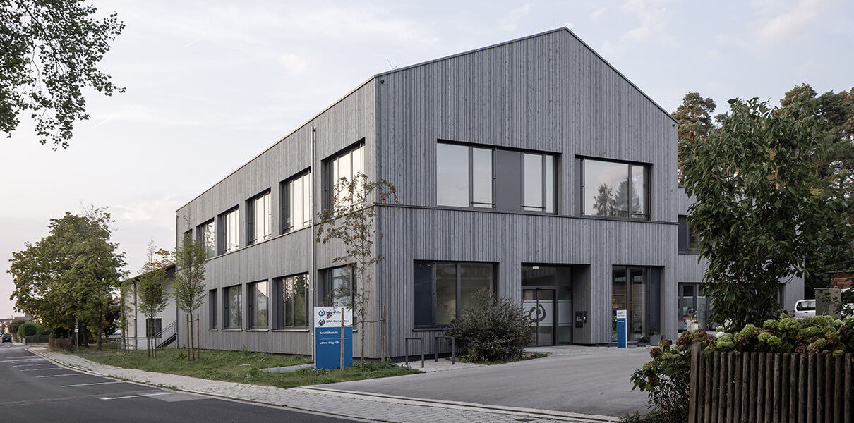 Blick auf das Gebäude der JURA Werkstätten mit der Holzfassade