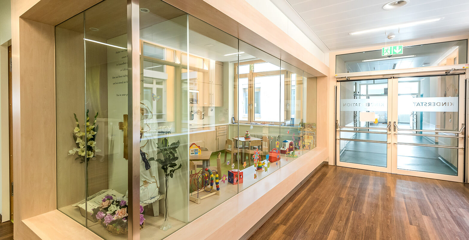 Eingangsbereich der Kinderstation. Doppeltür und Wartebereich mit Spielzeug für Kinder