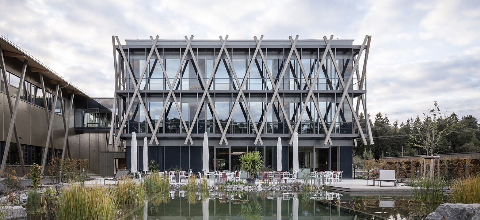 Blick auf den Außenbereit der Hammerbach GmbH mit Terrrasse und Teich vor dem Verwaltungsgebäude