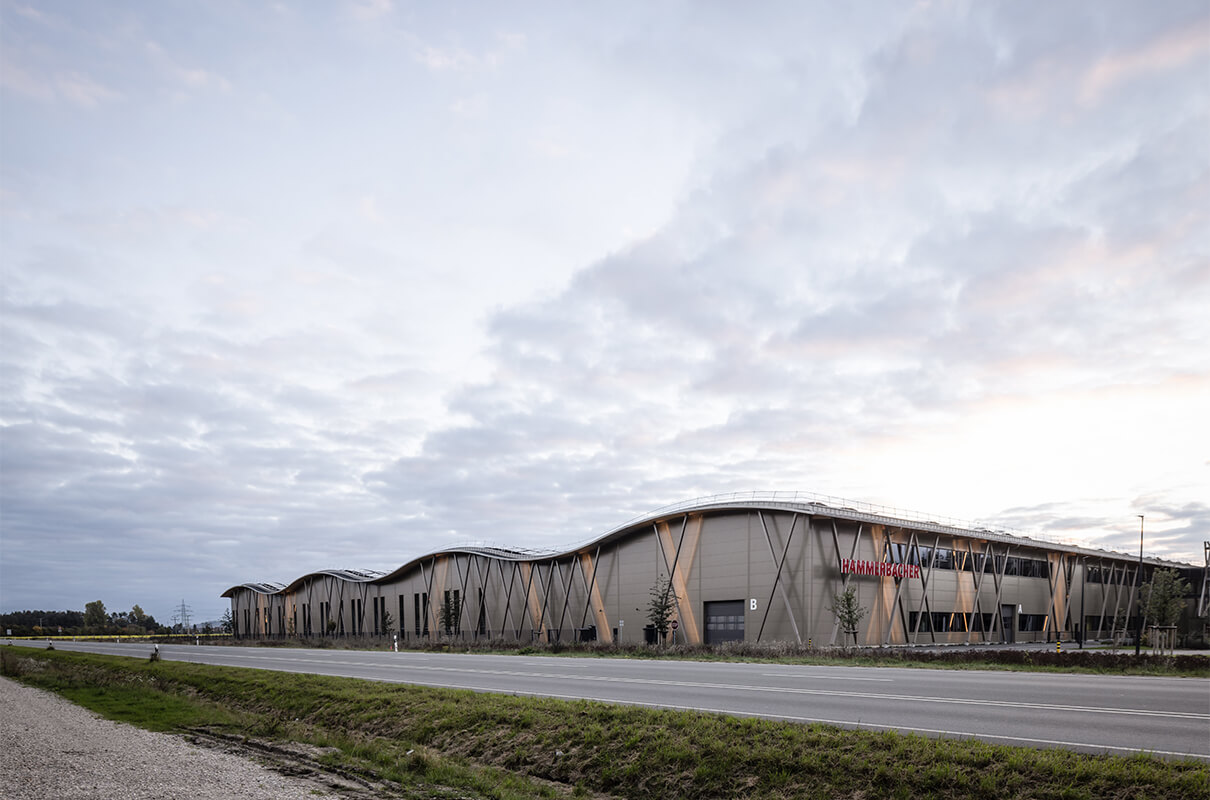 Ansicht der Lagerhalle der Hammerbacher GmbH von der Seite mit dem Logo Hammerbach auf der Holz-Alu-Außenkonstruktion