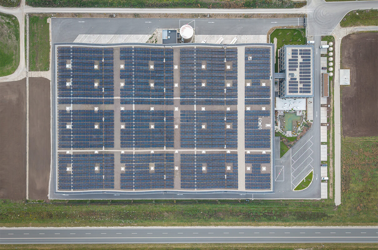 Luftaufnahme Blick direkt von oben aufs Dach. Das Dach ist mit einer Photovoltaikanlage komplett bestückt.